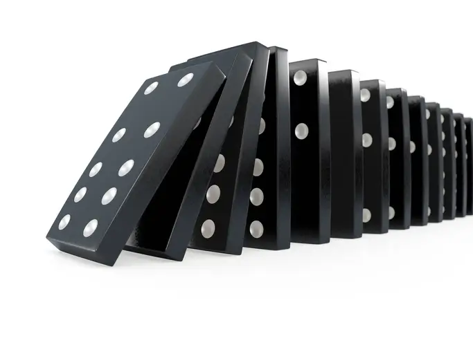 Dominoes falling over in a line signifying the domino effect if you don't plan for turnover by having a proper succession plan.